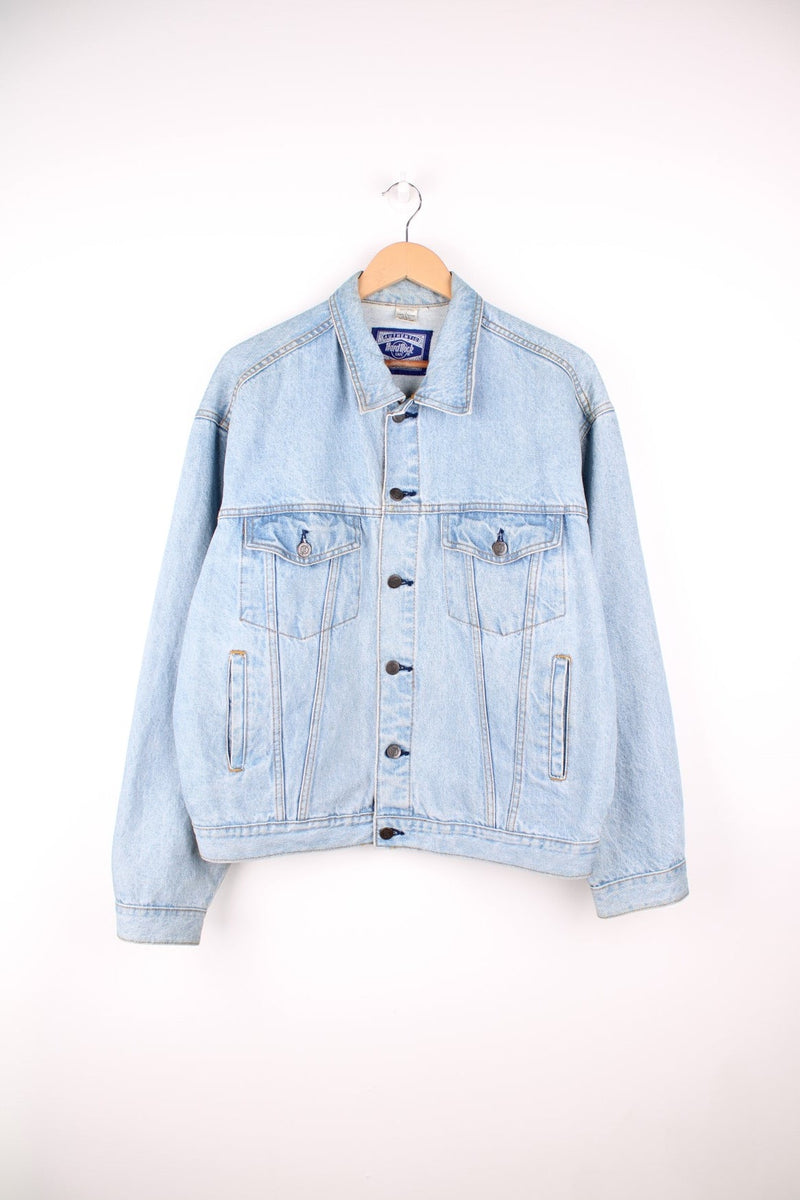 Hard Rock Cafe Denim Jacket in a light blue colourway, button up with multiple pockets, and has the logo embroidered on the back. 