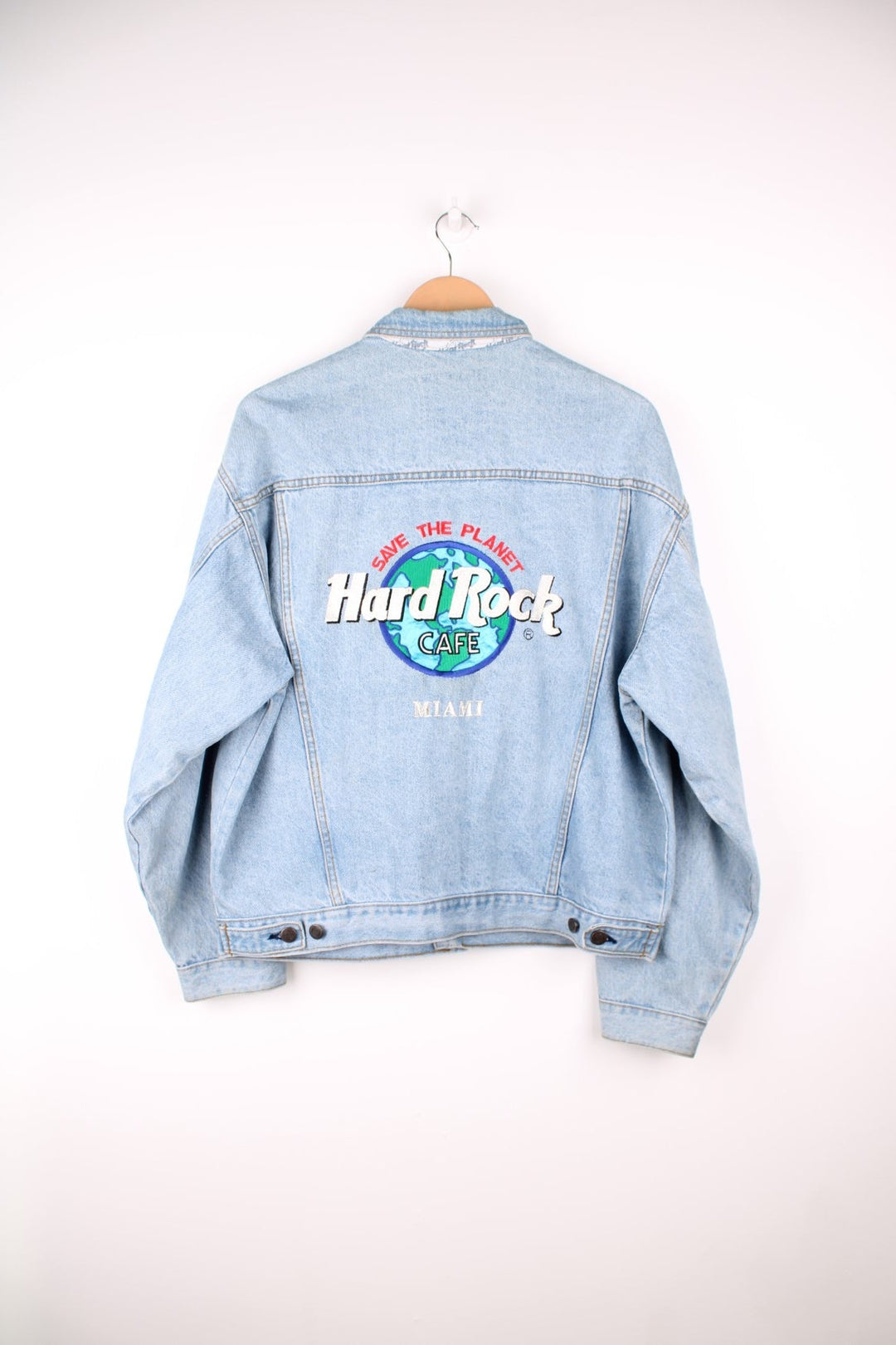 Hard Rock Cafe Denim Jacket in a light blue colourway, button up with multiple pockets, and has the logo embroidered on the back. 