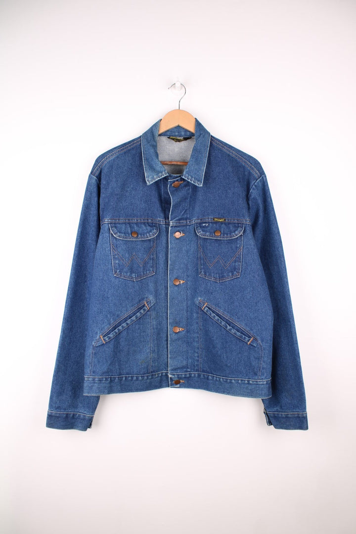 Wrangler Denim Jacket in a blue colourway with contrast stitching patterns throughout, button up with multiple pockets and has the logo embroidered on the front. 