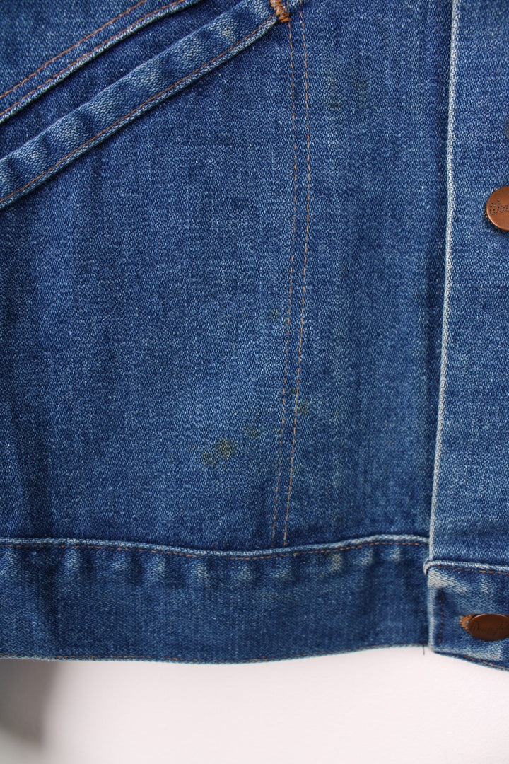 Wrangler Denim Jacket in a blue colourway with contrast stitching patterns throughout, button up with multiple pockets and has the logo embroidered on the front. 