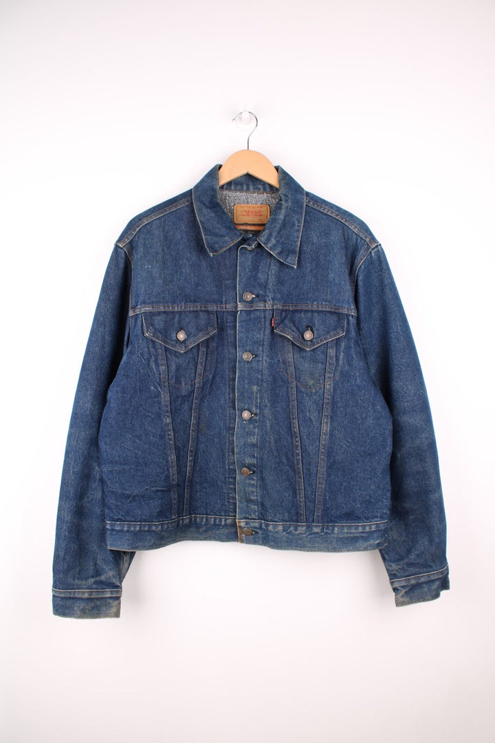 Levi's Denim Jacket in a blue colourway, button up with double chest pockets, has a blanket lining, and the logo embroidered on the front. 