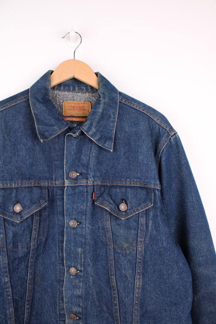 Levi's Denim Jacket in a blue colourway, button up with double chest pockets, has a blanket lining, and the logo embroidered on the front. 