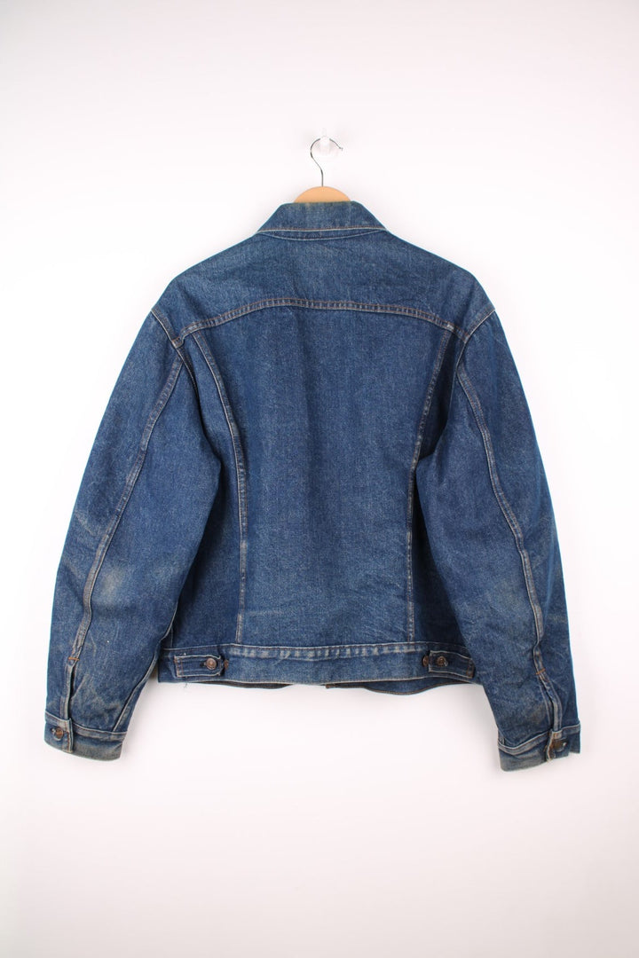 Levi's Denim Jacket in a blue colourway, button up with double chest pockets, has a blanket lining, and the logo embroidered on the front. 