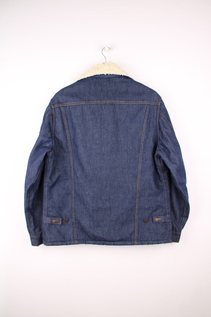 Vintage 70's Sears Roebuck Denim Sherpa Jacket in a blue colourway with a cream sherpa lining, button up with a camp collar, has multiple pockets and the logo embroidered on the front. 