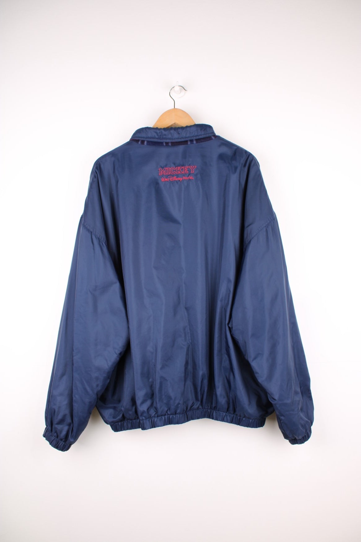 Disney World Reversible Jacket in either a navy blue waterpoof or a tartan fleece colourway, zip up with side pockets, and on the waterproof side has the logo embroidered on the chest. 