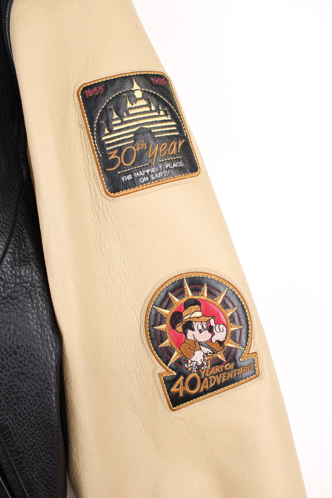 Disneyland Resort 50th Year Anniversary Leather Varsity Jacket in a black and cream colourway, zip up with side pockets, badges going down the sleeves, and has the spell out and Mickey Mouse embroidered on the front and back. 