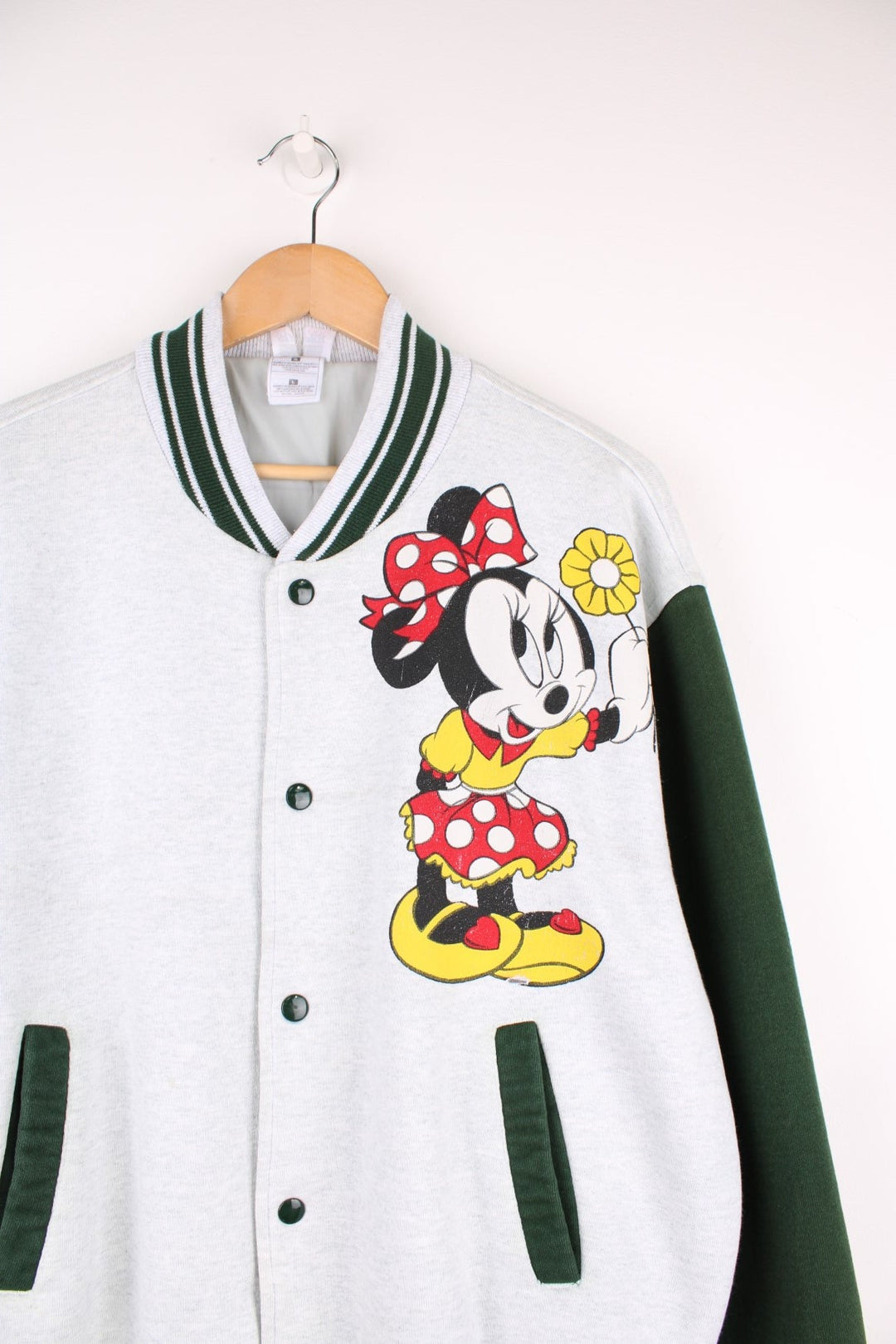 Vintage Disney Minnie Mouse Cotton Varsity Jacket in a grey and green colourway, button up with side pockets, has a nylon lining, and Minnie Mouse printed on the front. 