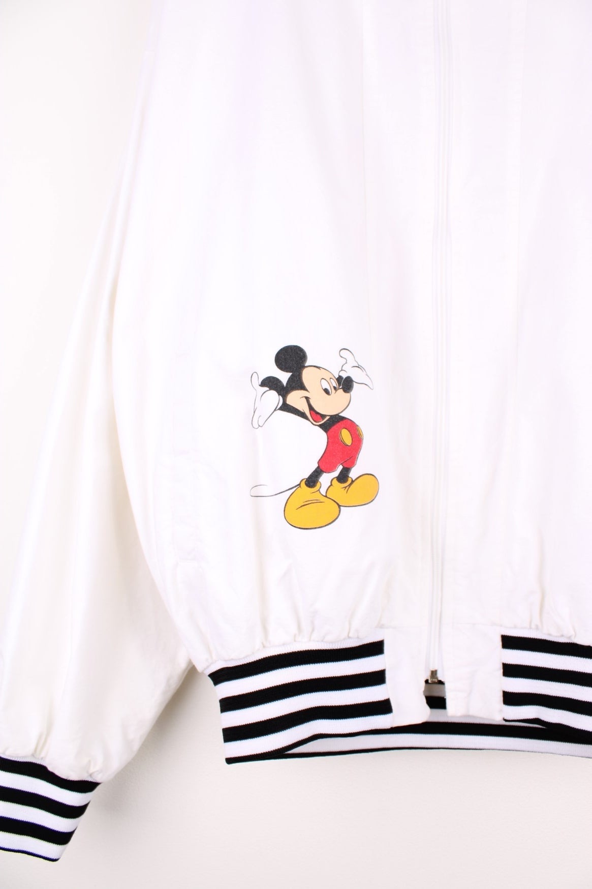 Disney Epcot Center Coach Jacket in a white and black colourway, zip up with side pockets, has a nylon lining, Mickey Mouse and the &