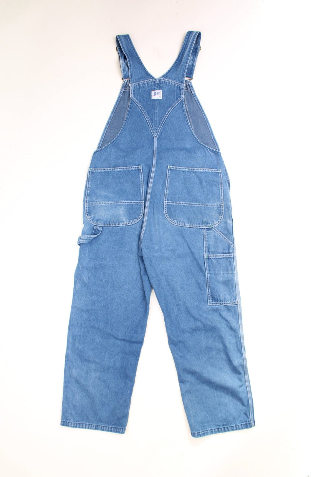 Liberty light wash denim dungarees with green accents, multiple pockets and a hammer loop. 