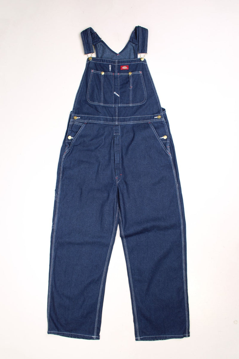 Dark wash Dickies dungarees with multiple pockets, white contrast stitch and red Dickies logos on the front and back.