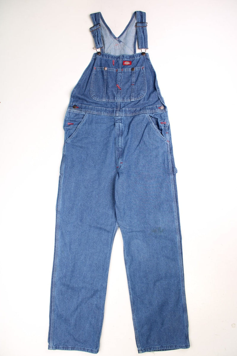 Dickies Dungarees in a blue denim colourway with multiple utility pockets and the logo embroidered on the front. 