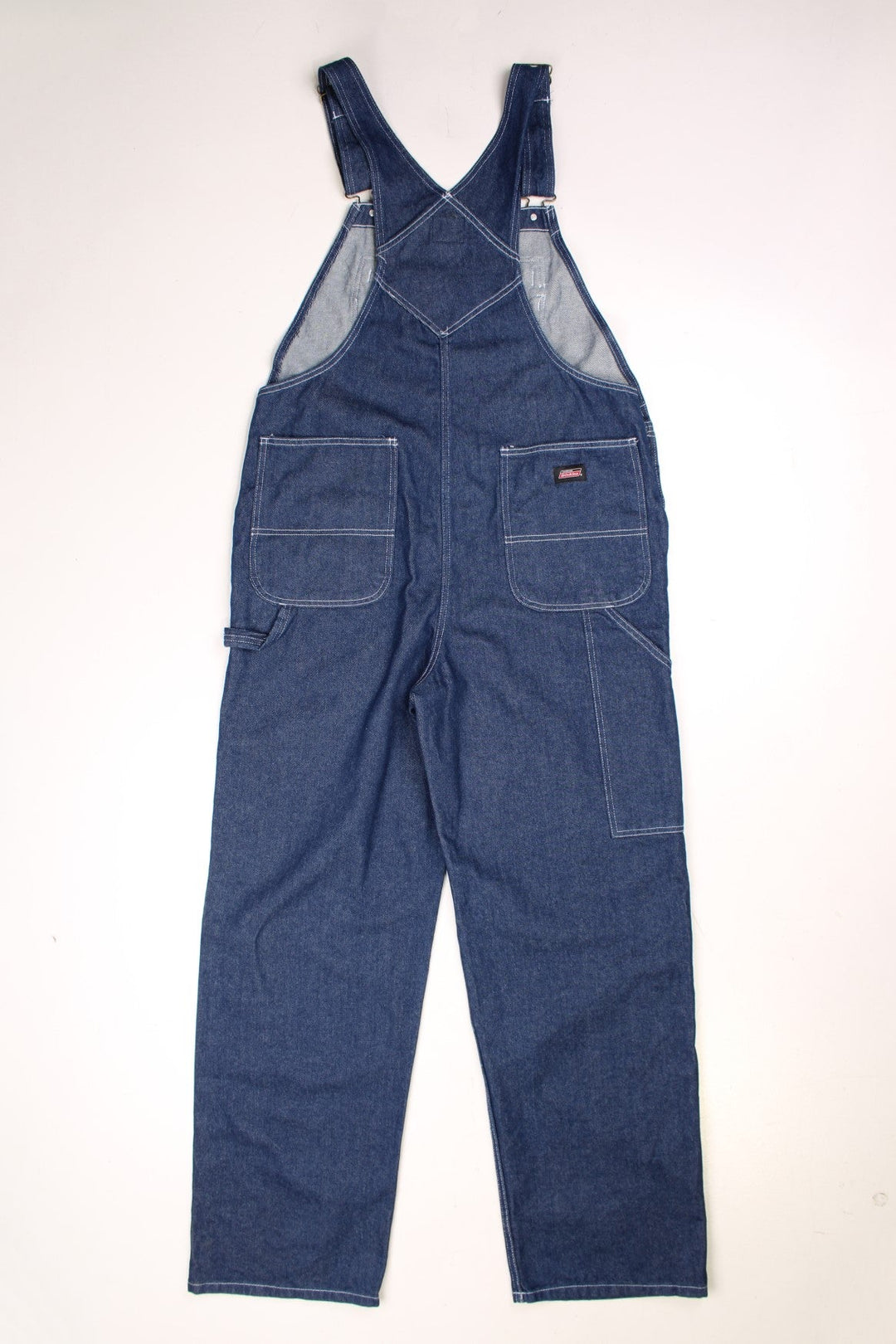 Dark wash Dickies dungarees with multiple pockets, white contrast stitch, a red accented zip pocket, and Dickies logos on the front and back.