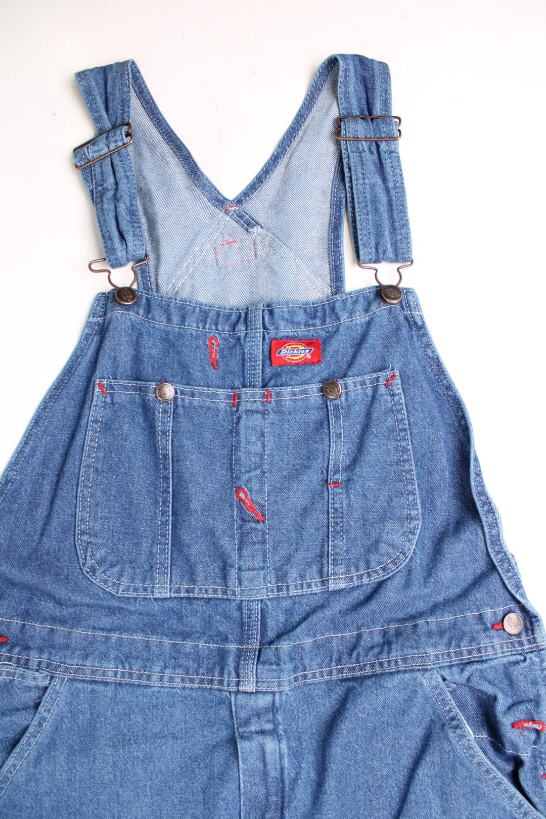 Dickies Dungarees in a blue denim colourway with multiple utility pockets and the logo embroidered on the front. 