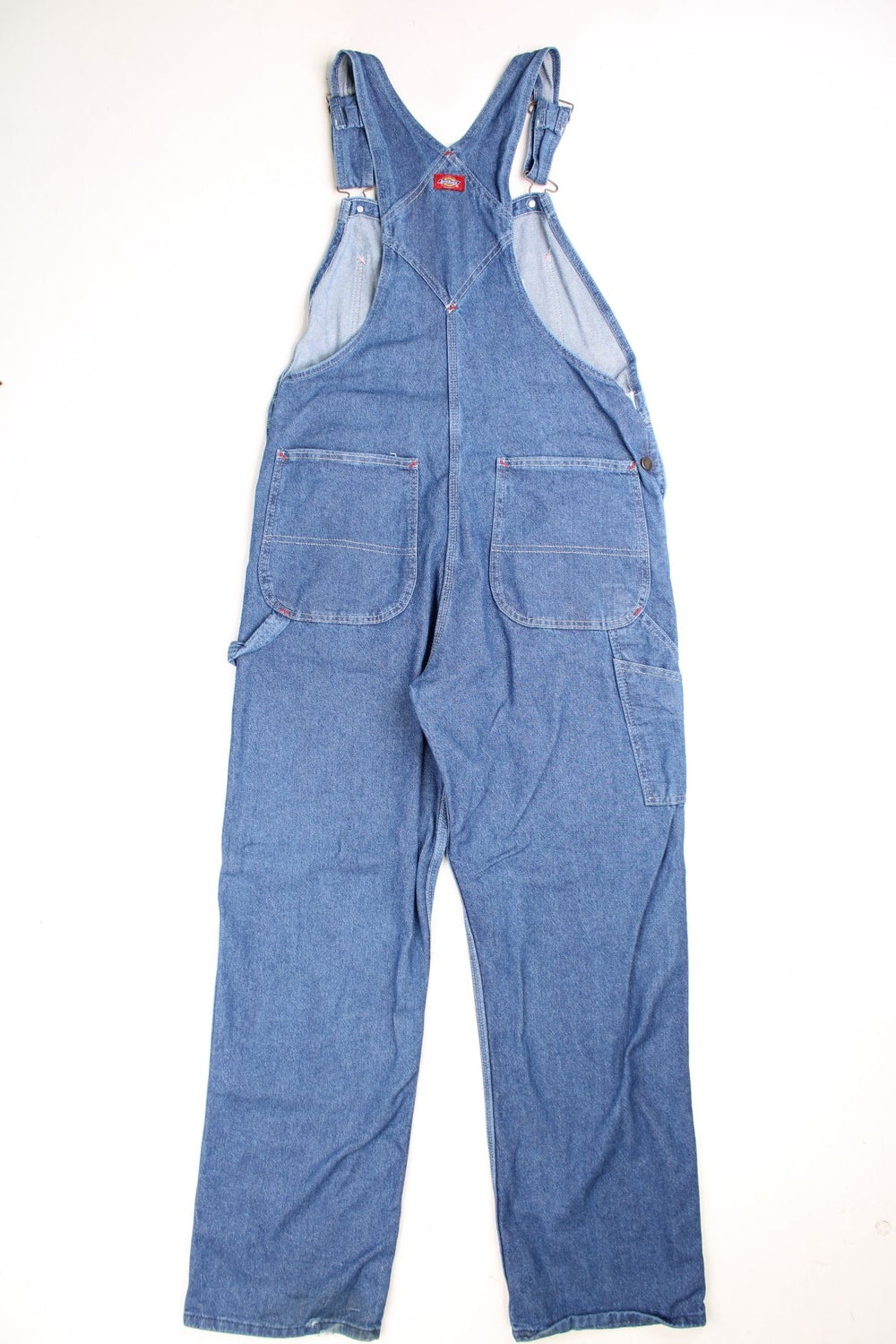 Dickies Dungarees in a blue denim colourway with multiple utility pockets and the logo embroidered on the front. 