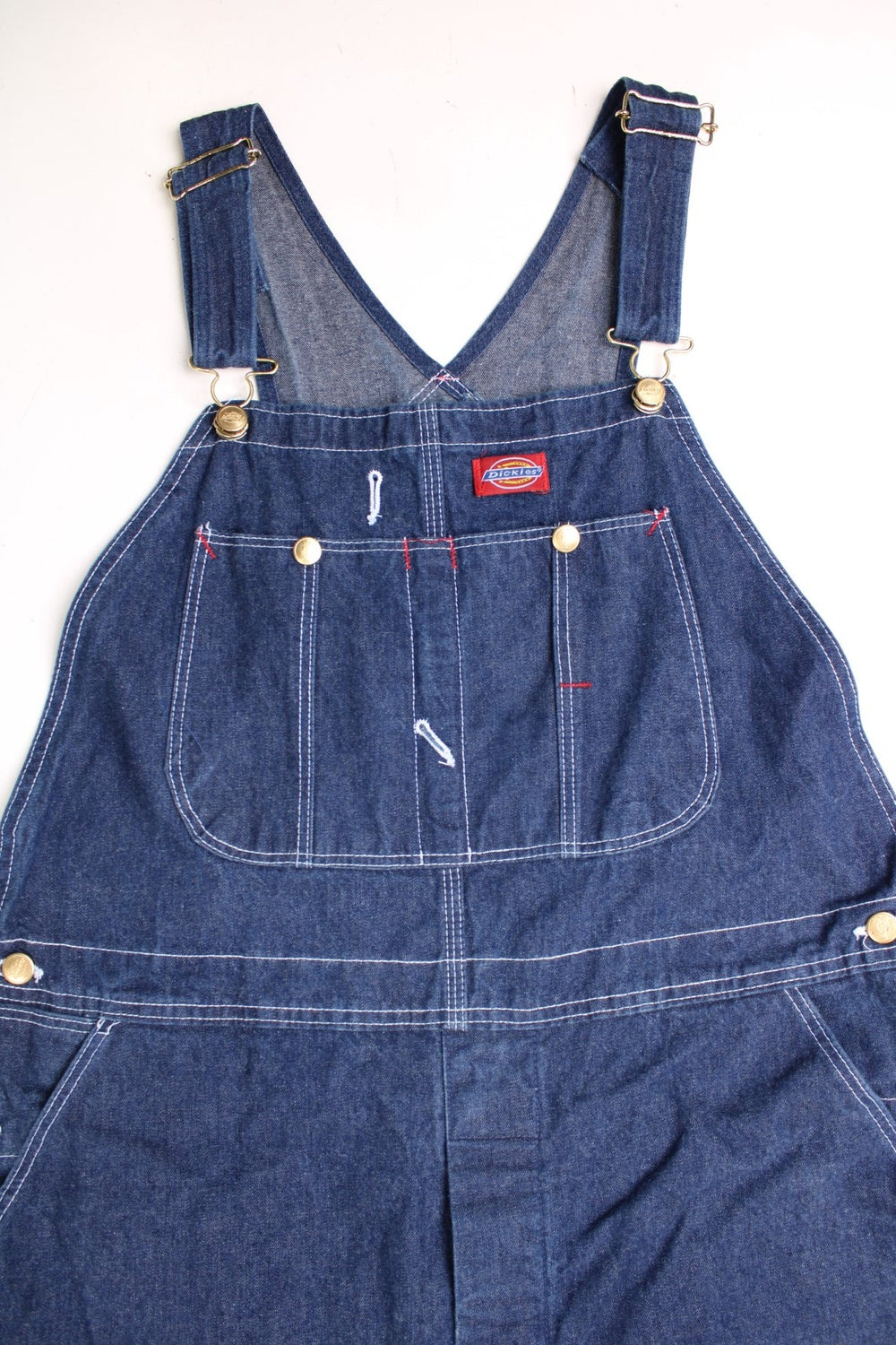 Dickies Dungarees in a blue denim colourway with multiple utility pockets and the logo embroidered on the front. 