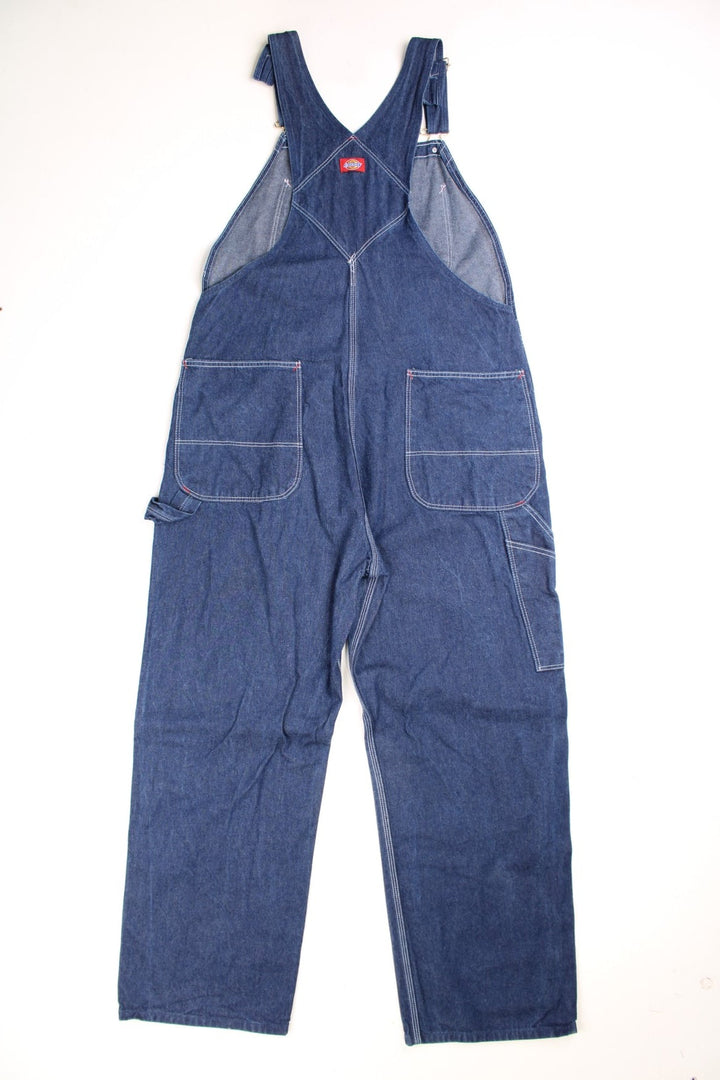 Dickies Dungarees in a blue denim colourway with multiple utility pockets and the logo embroidered on the front. 