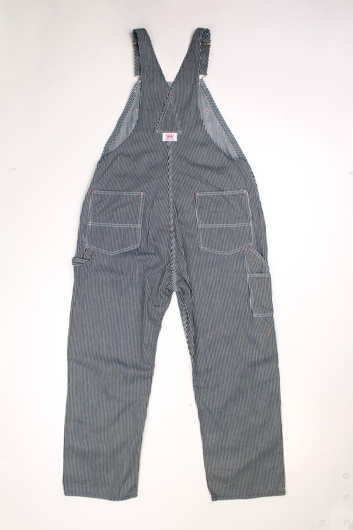 Roundhouse dark blue and white vertical striped dungarees with multiple pockets and logo patches on the front and back. 