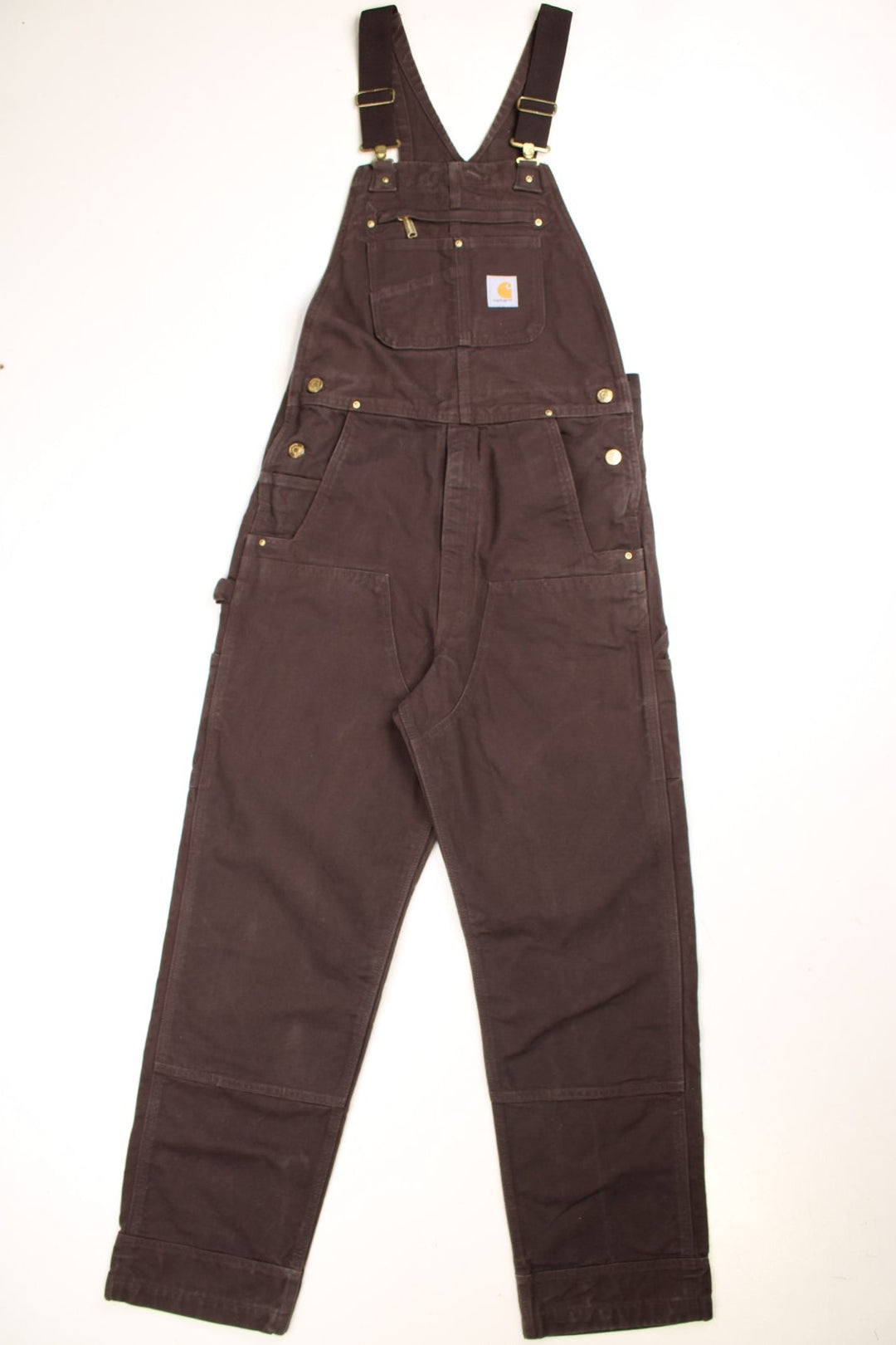 Carhartt carpenter-style dungarees in brown with black straps, multiple pockets, and a logo patch.