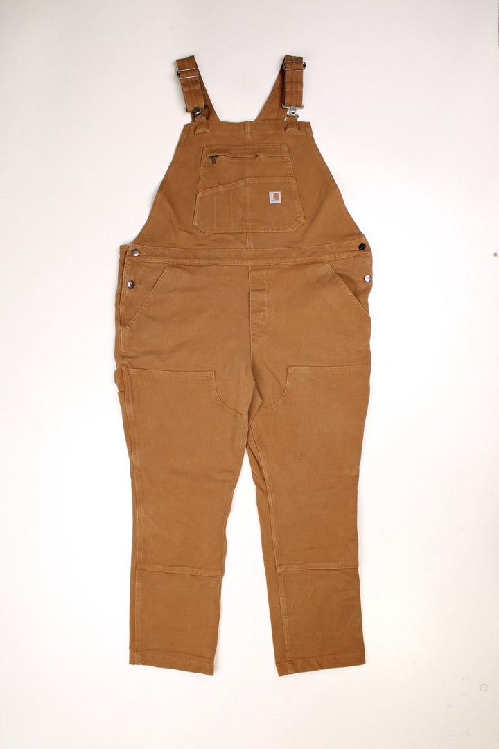 Ochre brown Carhartt carpenter-style dungarees with multiple pockets. 