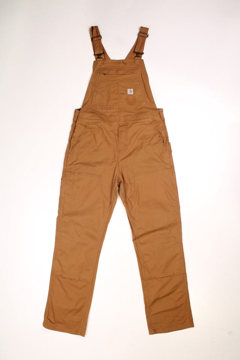 Ochre brown Carhartt carpenter-style dungarees with multiple pockets and sewn-in elastic to expand the waist size. 