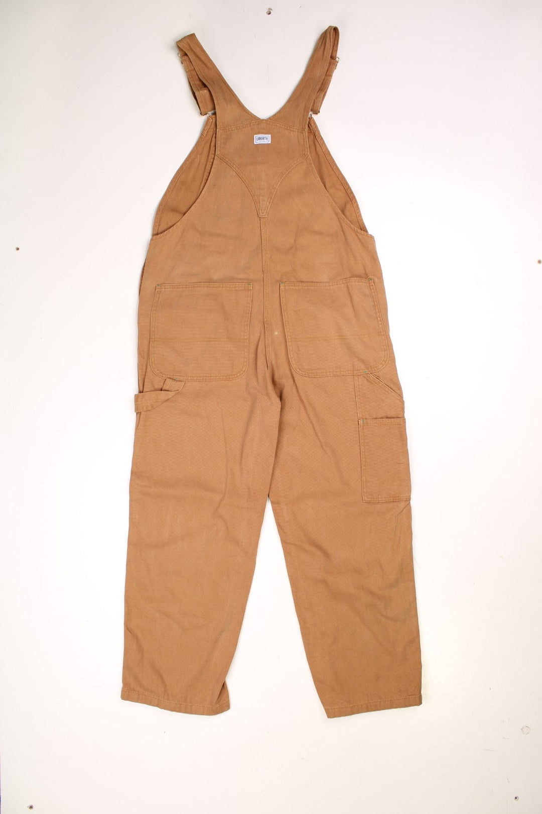 Tan Liberty dungarees with green accents, multiple pockets, logos front and back. 