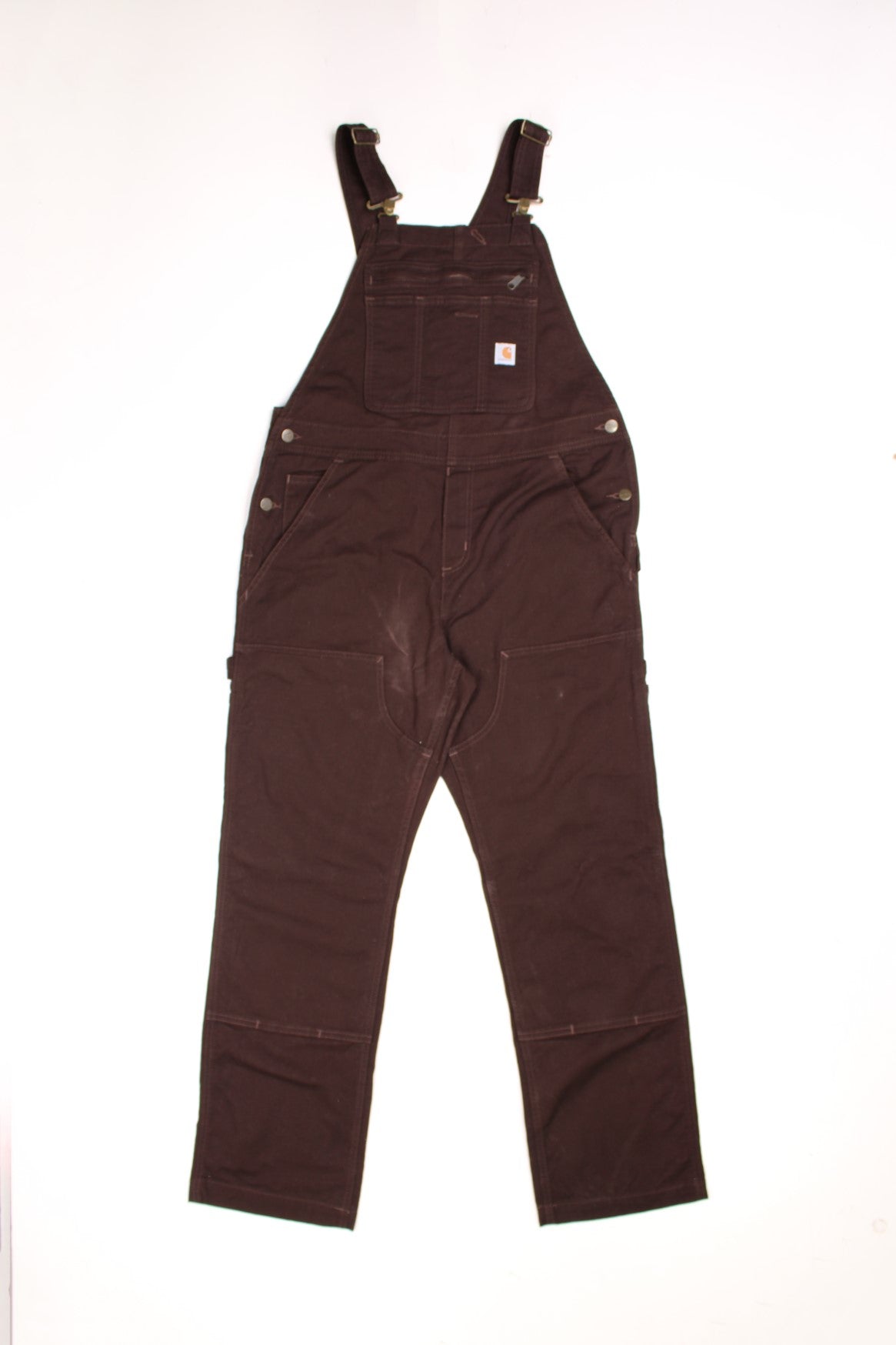 Dark brown carpenter-style Carhartt dungarees with multiple pockets, branded hardware, and a hammer loop.  