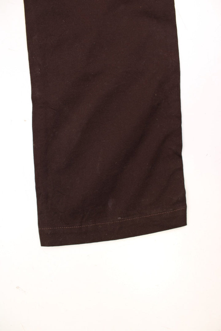 Dark brown carpenter-style Carhartt dungarees with multiple pockets, branded hardware, and a hammer loop.  