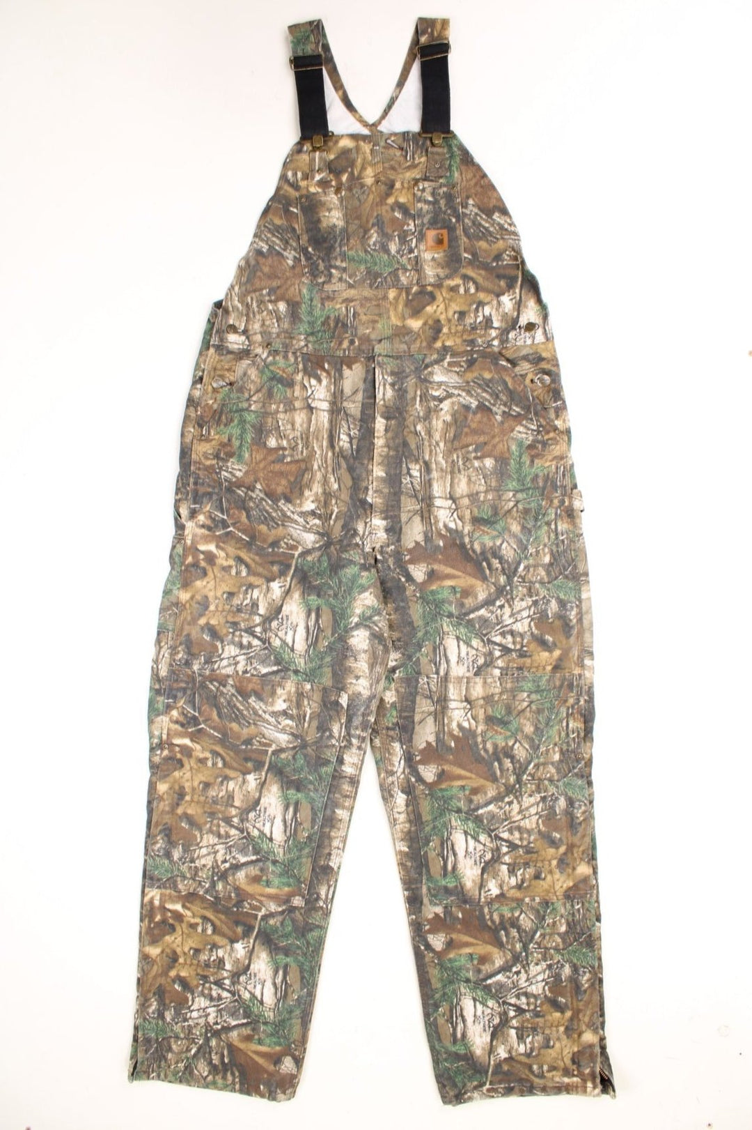 Carhartt double knee duck bib Realtree overalls with quilt lining. Features embroidered leather logo, zip half way up both legs and multiple pockets.