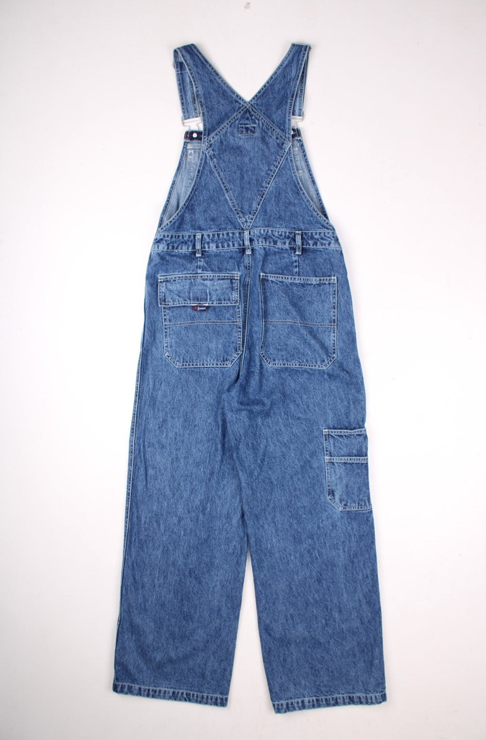 Calvin Klein Jeans denim dungarees in blue with multiple pockets, belt loops, and small logo patches on the front and back.