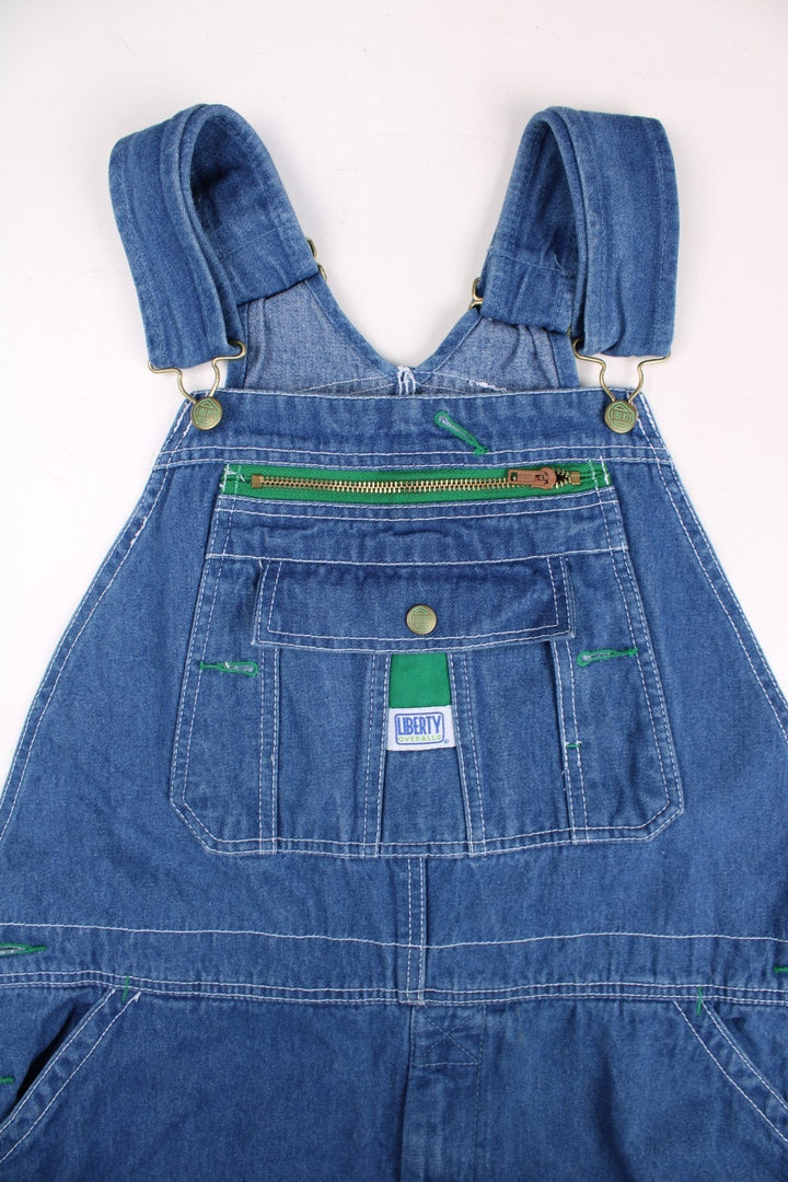 Vintage Liberty denim dungarees in blue with multiple pockets, branded hardware, and a Liberty Overalls patch on the front.