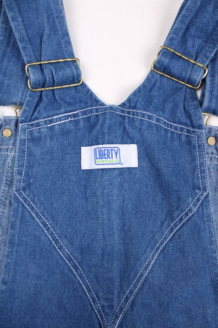 Vintage Liberty denim dungarees in blue with multiple pockets, branded hardware, and a Liberty Overalls patch on the front.