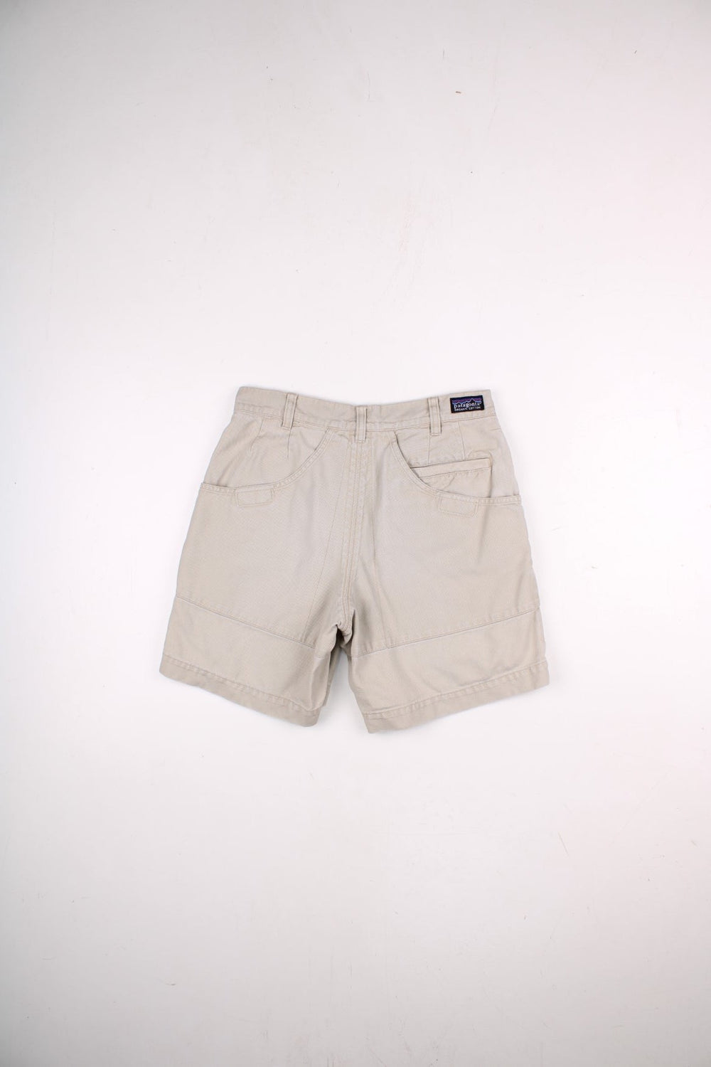 Patagonia shorts in tan with multiple pockets, zip and button closure, and a small logo on the back.