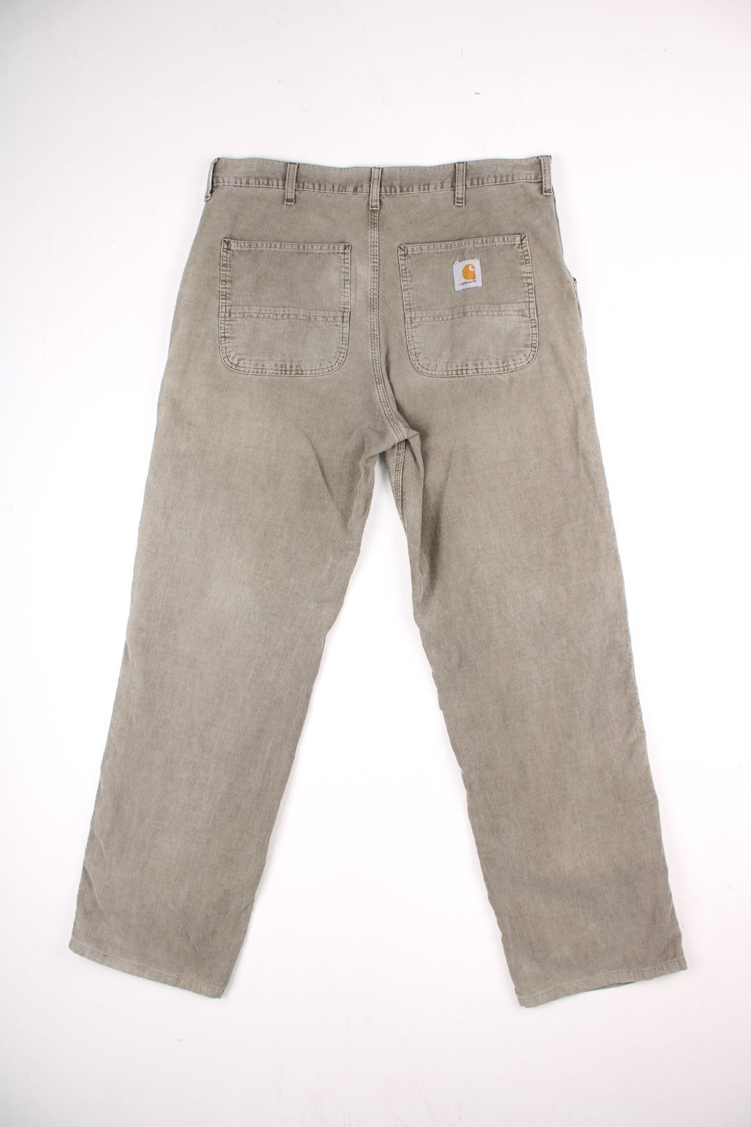 Carhartt corduroy trousers in tan with multiple pockets, zip and button closure, and a logo patch on the back pocket.