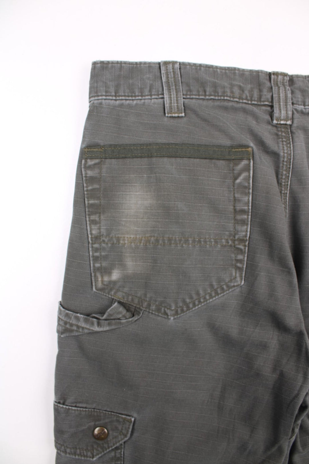 Carhartt cargo trousers in khaki green with multiple pockets, zip and button closure, and a logo patch on the back pocket.