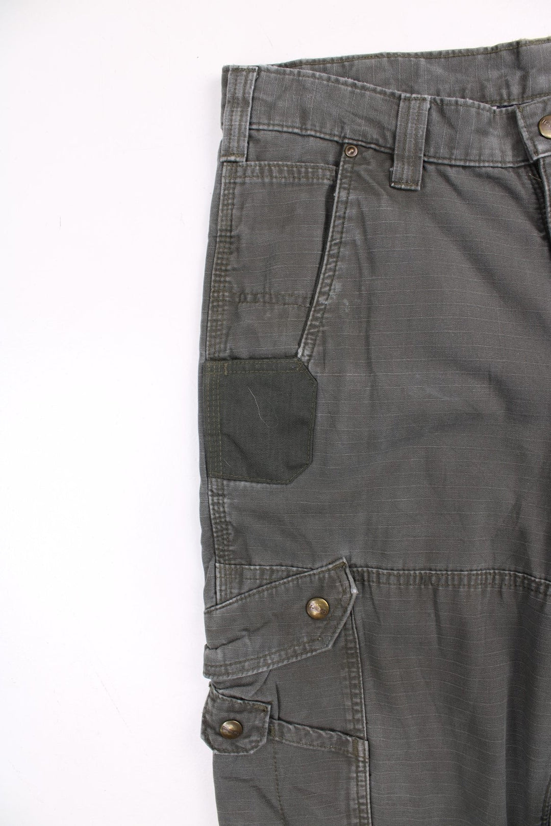 Carhartt cargo trousers in khaki green with multiple pockets, zip and button closure, and a logo patch on the back pocket.