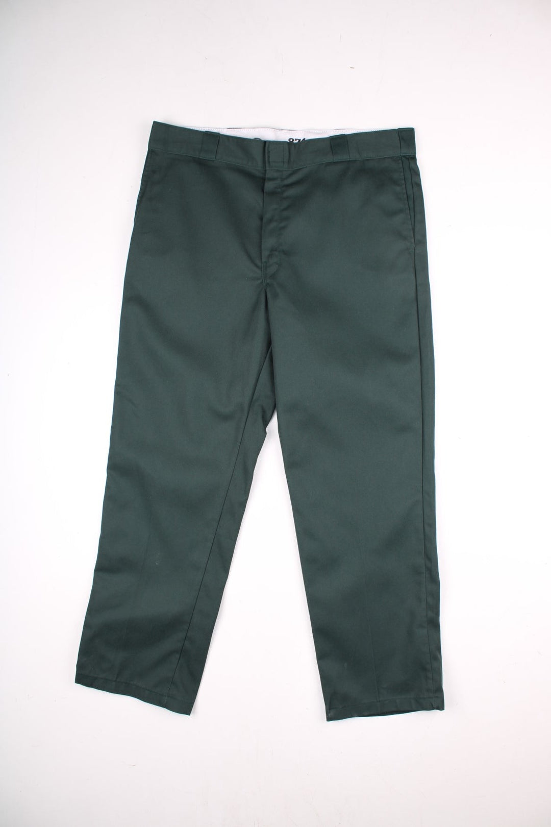 Dickies work trousers in green with multiple pockets, zip and button closure, and a logo patch on the back.