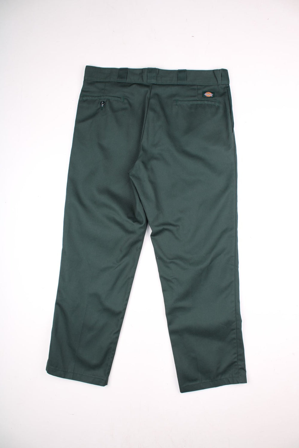 Dickies work trousers in green with multiple pockets, zip and button closure, and a logo patch on the back.