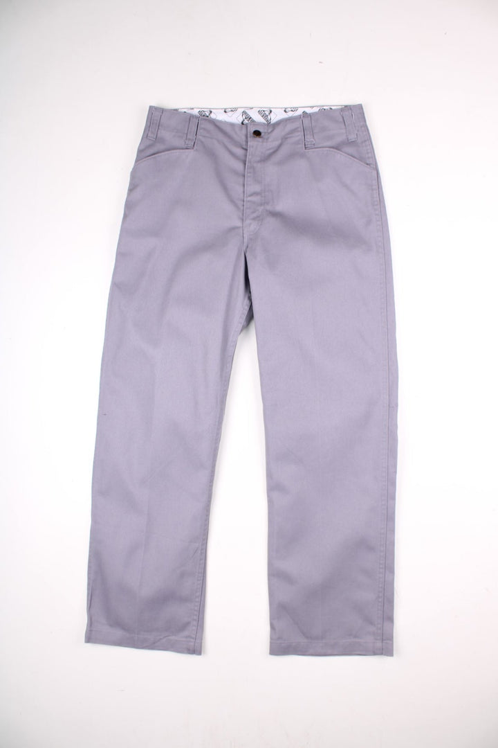 Ben Davis work  trousers in grey with multiple pockets, zip and button closure, and a logo patch on the back.