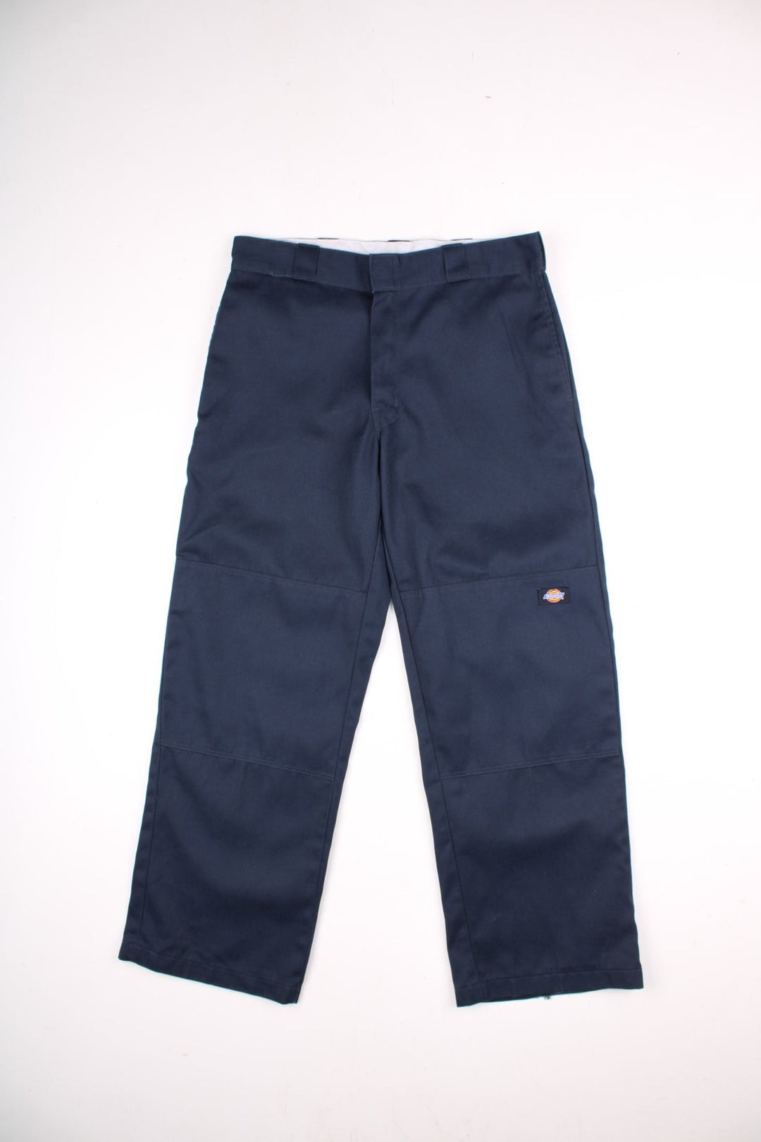 Dickies double-knee work trousers in navy blue with multiple pockets, zip and button closure, and a logo patch on the front.