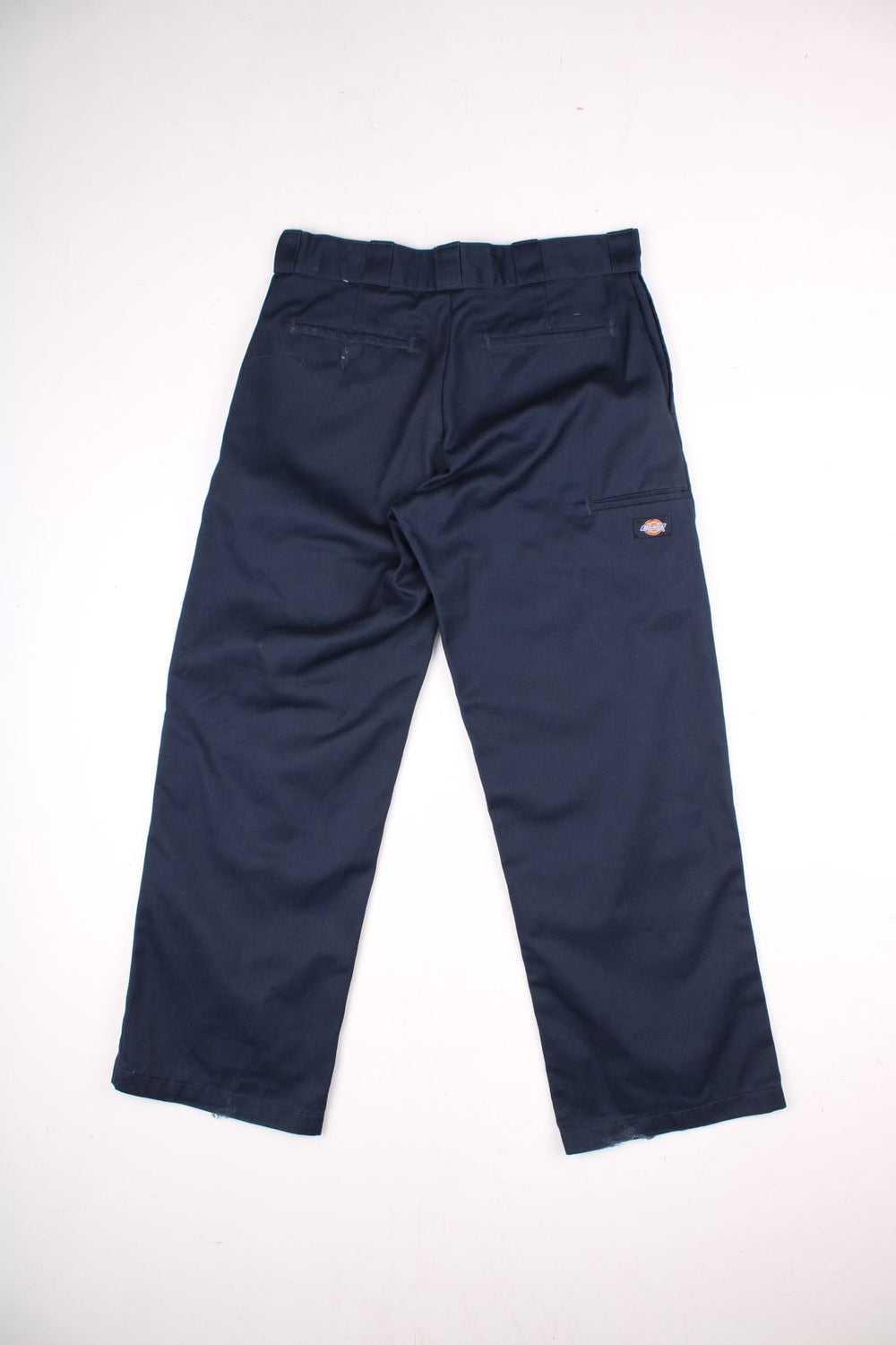 Dickies double-knee work trousers in navy blue with multiple pockets, zip and button closure, and a logo patch on the front.