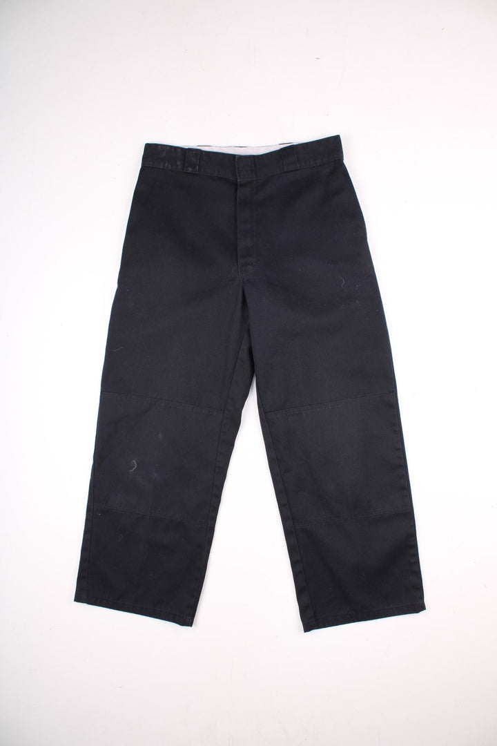 Dickies double-knee work trousers in black with multiple pockets and zip and button closure.