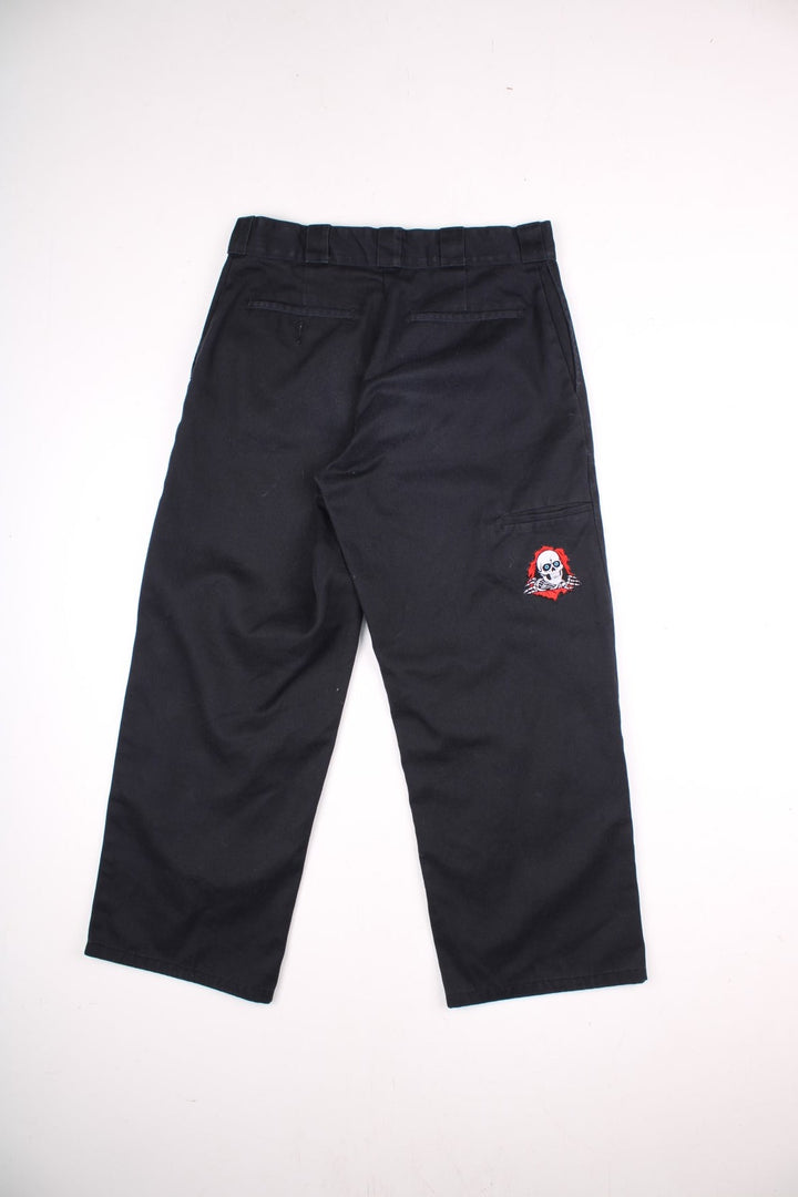 Dickies double-knee work trousers in black with multiple pockets and zip and button closure.