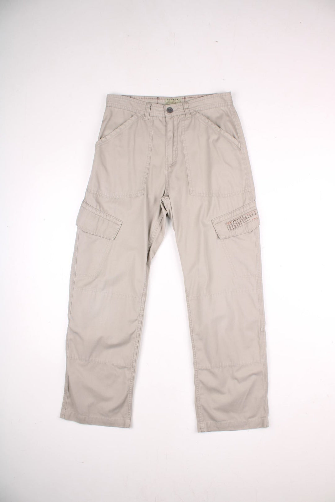 Oakley cargo trousers in tan with multiple pockets, zip and button closure, and a logo patch on the back.