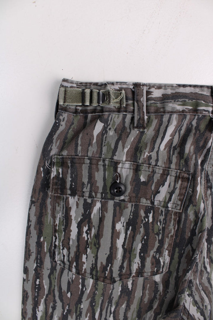 Vintage Realtree camouflage trousers in green and brown with multiple pockets and zip and button closure.