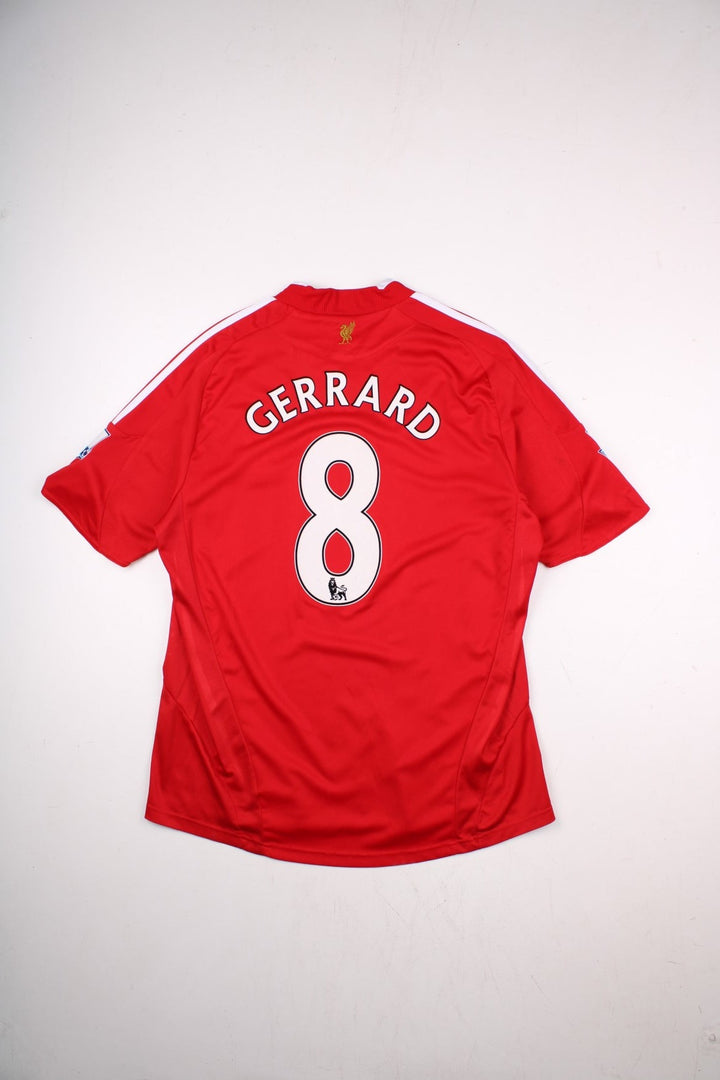 Liverpool 2008/09 Umbro Football Shirt in the red away kit colourway, features embroidered logos and badge on the front, and Gerrard number 8 printed on the back.