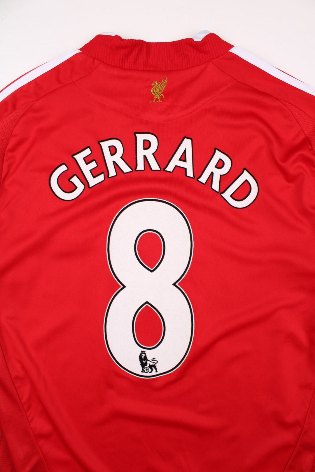 Liverpool 2008/09 Umbro Football Shirt in the red away kit colourway, features embroidered logos and badge on the front, and Gerrard number 8 printed on the back.