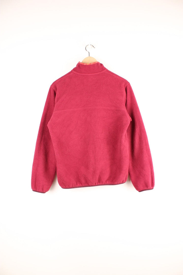 Dark Pink Patagonia Synchilla fleece with 1/4 snap closure, a breast pocket, red patterned detailing on the collar, and an embroidered logo patch.  