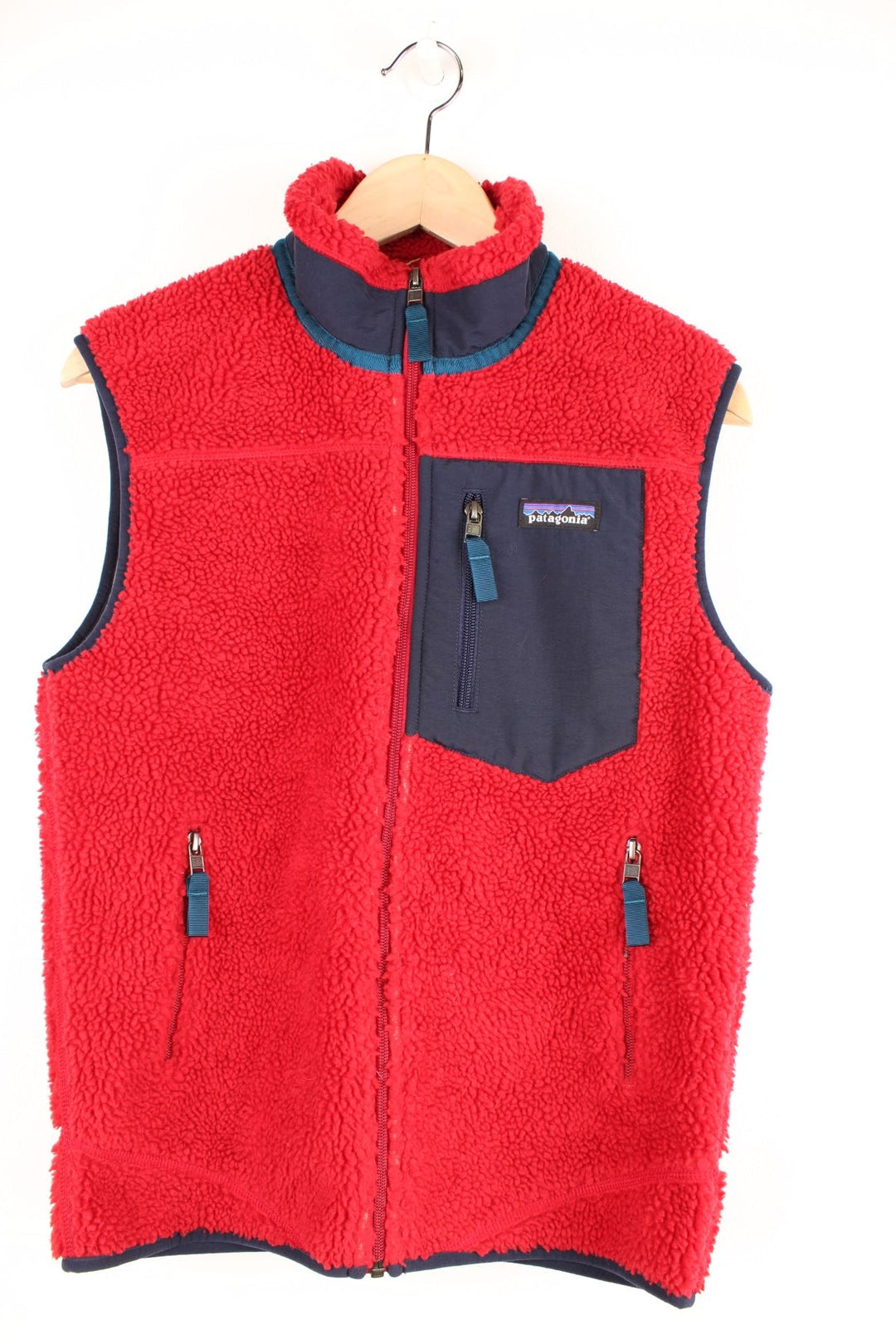 Red Patagonia fleece gilet with blue accents, zip closure, three zipped logos and an embroidered logo patch. 