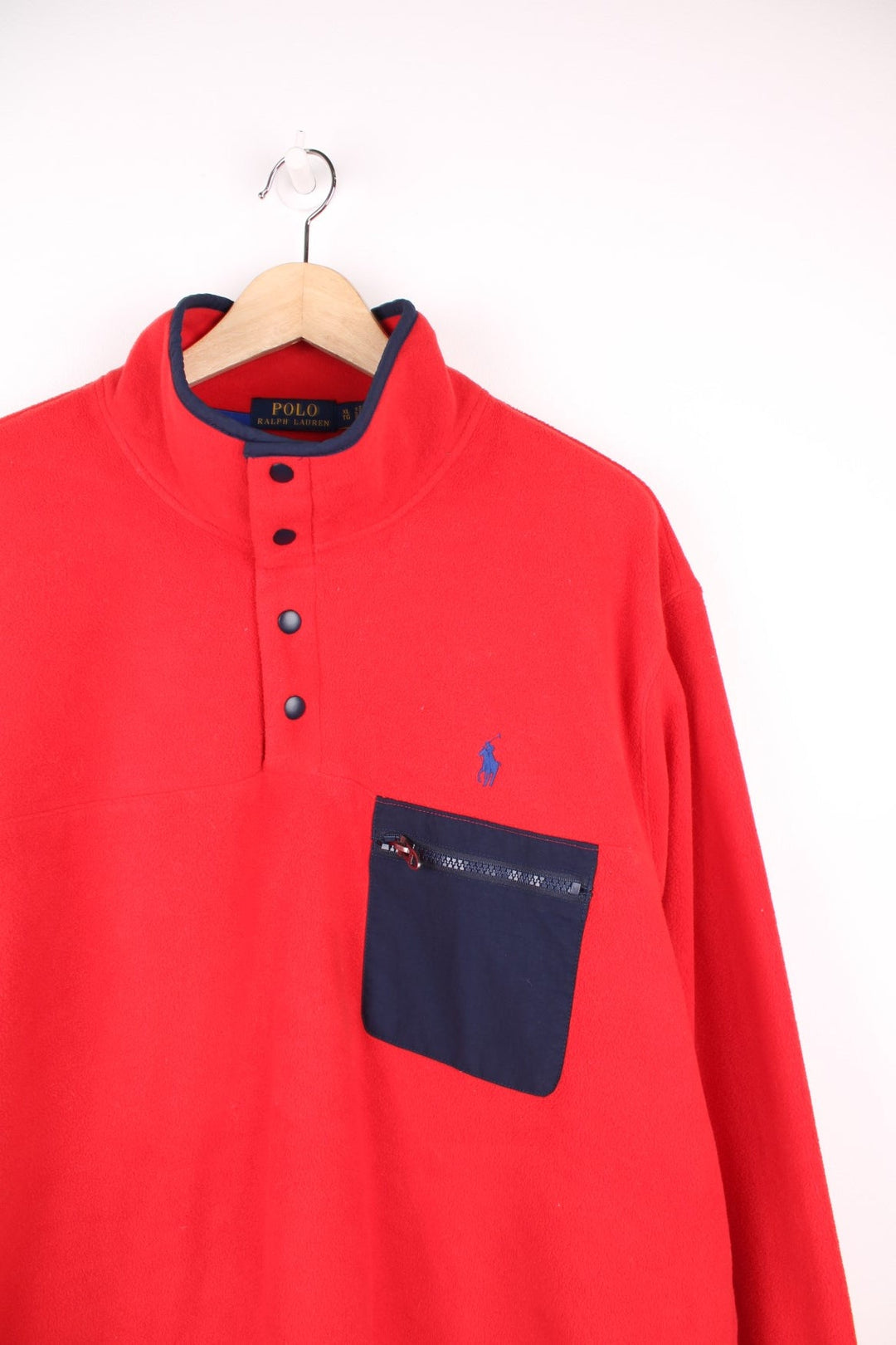 Red Polo quarter-zip with snap closure and contrasting navy blue trim and zip pocket. Classic Polo logo embroidered in blue. 