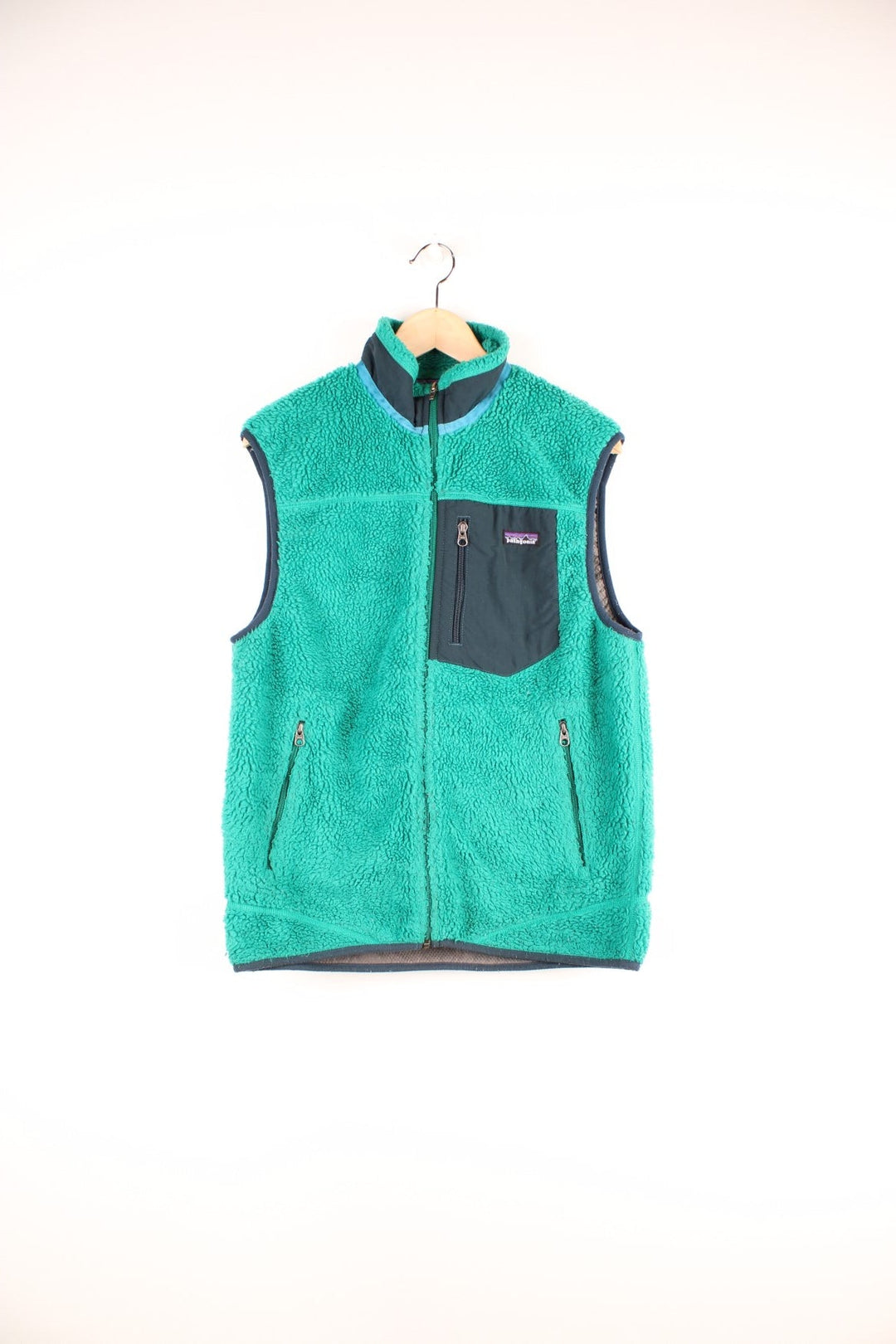 Green Patagonia zip-up fleece gilet with blue accents, three zipped pockets and a logo patch.  